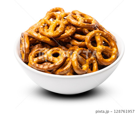 Small traditional beer pretzels with salt in a white ceramic bowl isolated on white background 128761957