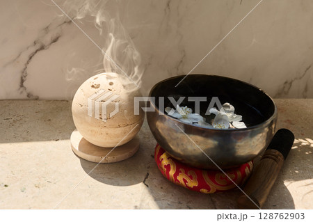 Zen Meditation Setup. A serene scene with a smoke sphere and singing bowl with flowers 128762903