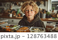 Portrait of a Blonde Curly Haired Boy with Blue Eyes Preparing His School Lunch 128763488