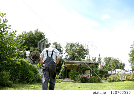Man walking on lawn in country house 128763559