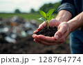 Close-up of hands holding a young green plant with soil, symbolizing growth, sustainability, and environmental care. Eco-friendly concept. Picture generated by AI 128764774