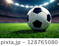 Close-up of a football soccer ball on a green field in a stadium. Football game background, sports concept, championship, match preparation. Picture generated by AI 128765080