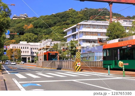【愛媛県】松山市役所前から見た秋の松山城と伊予鉄電車 128765380