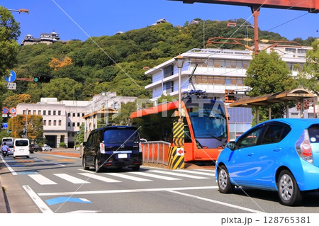 【愛媛県】松山市役所前から見た秋の松山城と伊予鉄電車 128765381