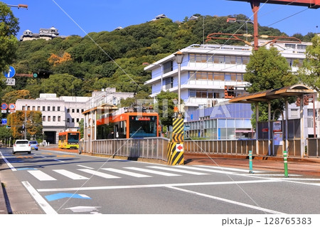 【愛媛県】松山市役所前から見た秋の松山城と伊予鉄電車 128765383