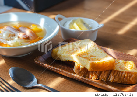 フレンチトーストと野菜スープ・フルーツヨーグルトが並ぶ朝の食卓 128765415