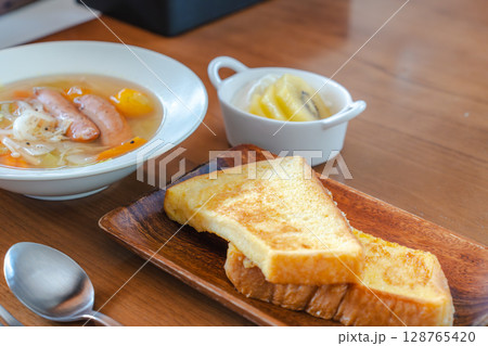 フレンチトーストと野菜スープ・フルーツヨーグルトが並ぶ朝の食卓 フレンチトーストと野菜スープ・フルーツヨーグルトが並ぶ朝の食卓 128765420