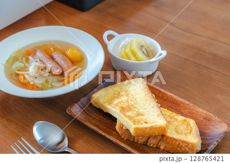 フレンチトーストと野菜スープ・フルーツヨーグルトが並ぶ朝の食卓 フレンチトーストと野菜スープ・フルーツヨーグルトが並ぶ朝の食卓 128765421