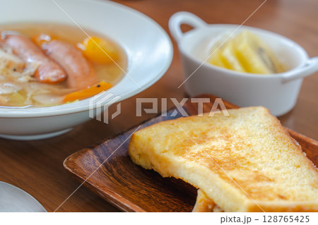 フレンチトーストと野菜スープ・フルーツヨーグルトが並ぶ朝の食卓 フレンチトーストと野菜スープ・フルーツヨーグルトが並ぶ朝の食卓 128765425