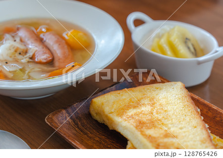 フレンチトーストと野菜スープ・フルーツヨーグルトが並ぶ朝の食卓 128765426