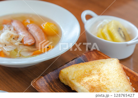 フレンチトーストと野菜スープ・フルーツヨーグルトが並ぶ朝の食卓 フレンチトーストと野菜スープ・フルーツヨーグルトが並ぶ朝の食卓 128765427