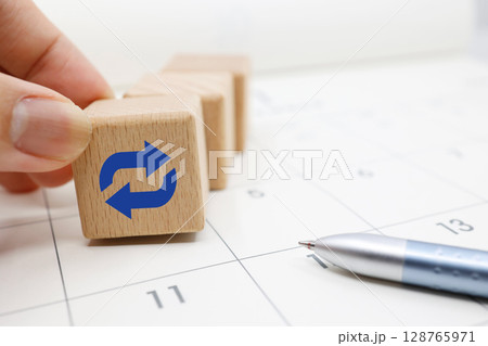 繰り返しスケジュールの概念を示すカレンダーと木のブロック 128765971
