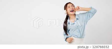 Listening music joyfully, Excited young Asian woman imitates singing into a microphone with hands together, living lifestyle full of emotions, sound, and happy music. isolated studio white background Listening music joyfully, Excited young Asian woman imitates singing into a microphone with hands together, living lifestyle full of emotions, sound, and happy music. isolated studio white background 128766032