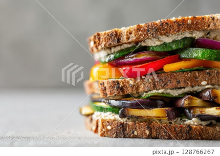 Vegan Sandwich with Rye Bread, Grilled Vegetables, and Hummus on Gray Background 128766267