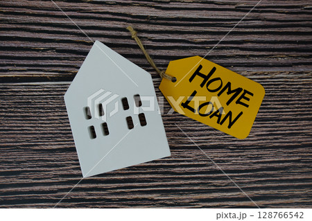 Home Loan text on price tag with white house model flat lay on wooden background Home Loan text on price tag with white house model flat lay on wooden background 128766542