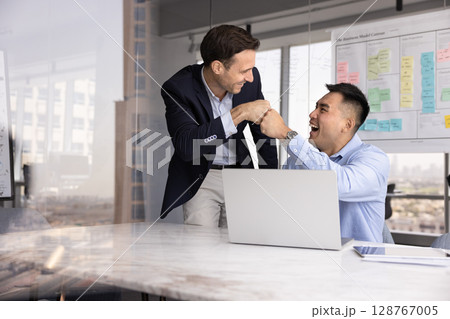 Positive diverse businessmen fist bumping, celebrate joint success 128767005