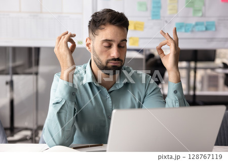 Male office employee take break, meditating during working day 128767119