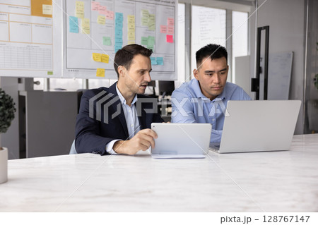 Teammates using two modern devices in office 128767147