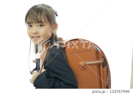新一年生の女の子がランドセルを背負って登校する様子 128767990