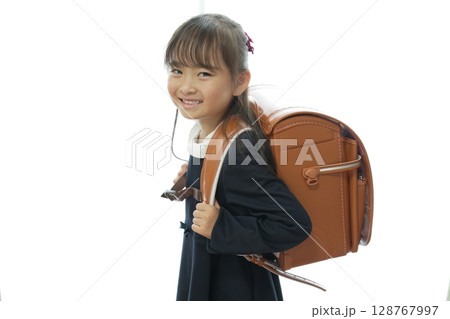 新一年生の女の子がランドセルを背負って登校する様子 128767997