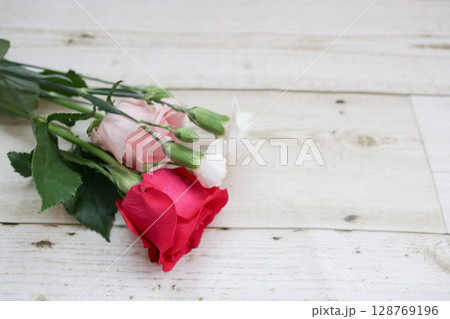 赤・ピンク・白のバラとカーネーションの花束と白い木目の背景 赤・ピンク・白のバラとカーネーションの花束と白い木目の背景 128769196