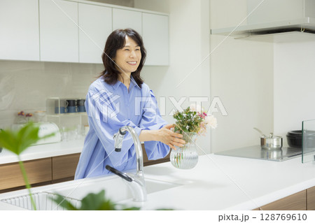 キッチンで花瓶を持つ女性 128769610