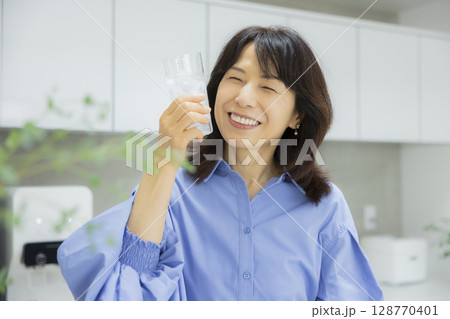 キッチンで水を飲む女性 128770401
