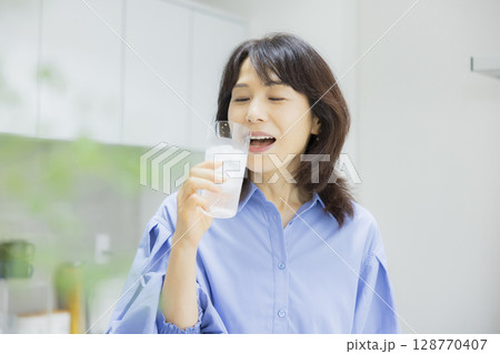 キッチンで水を飲む女性　 128770407