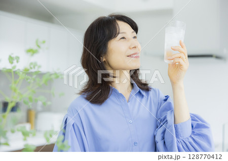 キッチンで水を飲む女性　 128770412