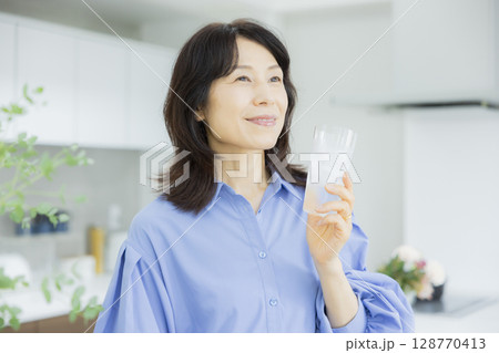 キッチンで水を飲む女性 キッチンで水を飲む女性 128770413