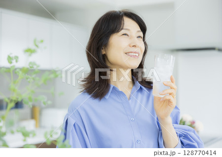 キッチンで水を飲む女性 キッチンで水を飲む女性 128770414