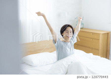 ベッドでストレッチする女性　 128770443