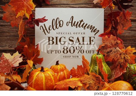 Hello Autumn Big Sale 80% text with maple leaf decoration on wooden background 128770612
