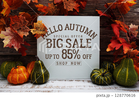 Hello Autumn Big Sale 85% text with maple leaf decoration on wooden background 128770616