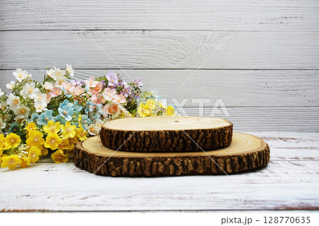 Wooden podium stand for product display with flower decoration on wooden background Wooden podium stand for product display with flower decoration on wooden background 128770635