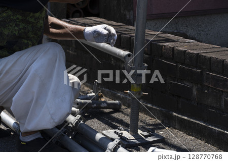 足場を組み立てる職人 128770768