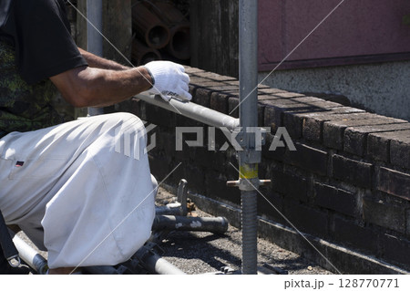 足場を組み立てる職人 128770771