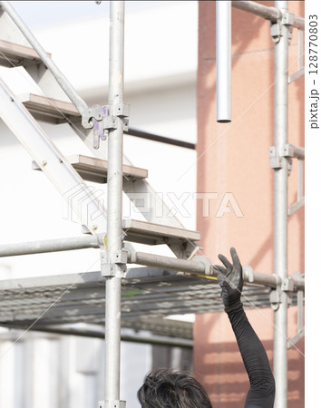 足場を組み立てる職人 128770803