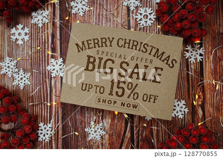 Merry Christmas Big Sale 15% text on paper card with Snowflake and LED light decoration on wooden background Merry Christmas Big Sale 15% text on paper card with Snowflake and LED light decoration on wooden background 128770855