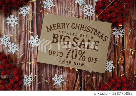 Merry Christmas Big Sale 70% text on paper card with Snowflake and LED light decoration on wooden background 128770885