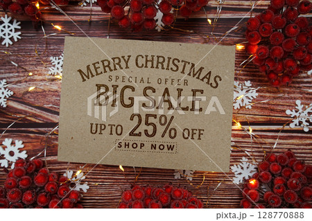Merry Christmas Big Sale 25% text on paper card with Snowflake and LED light decoration on wooden background 128770888