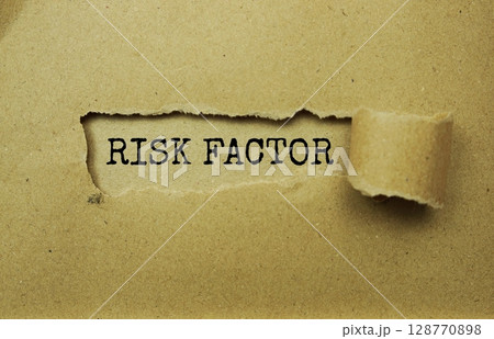 Risk Factor message written on craft paper with torn paper background 128770898