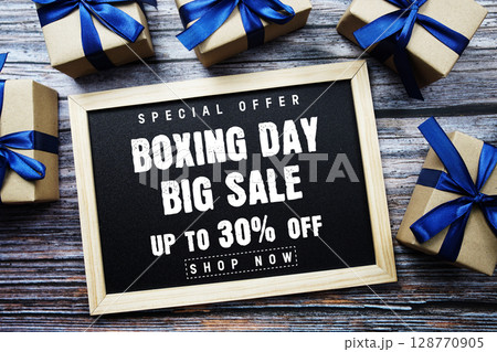Boxing Day Big Sale 30% Off text on blackboard with present gifts on wooden background Boxing Day Big Sale 30% Off text on blackboard with present gifts on wooden background 128770905