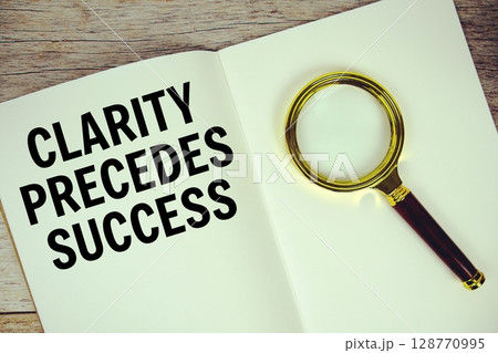 Clarity Precedes Success text message written on paper note with magnifying glass top view on wooden background Clarity Precedes Success text message written on paper note with magnifying glass top view on wooden background 128770995
