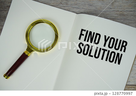 Find Your Solution text message written on paper note with magnifying glass top view on wooden background 128770997