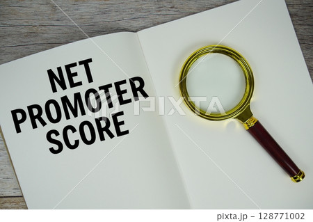 Net Promoter Score text message written on paper note with magnifying glass top view on wooden background 128771002