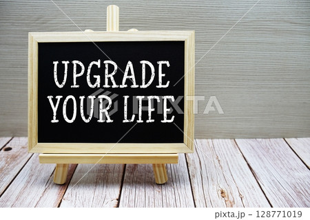 Upgrade Your Life text written on chalkboard with easel on wooden background Upgrade Your Life text written on chalkboard with easel on wooden background 128771019