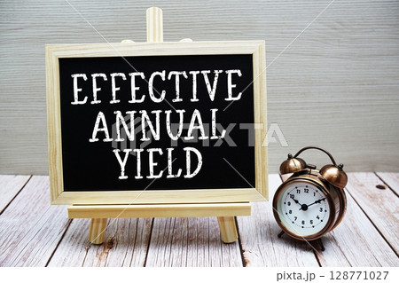 Effective Annual Yield text written on chalkboard with alarm clock on wooden background Effective Annual Yield text written on chalkboard with alarm clock on wooden background 128771027