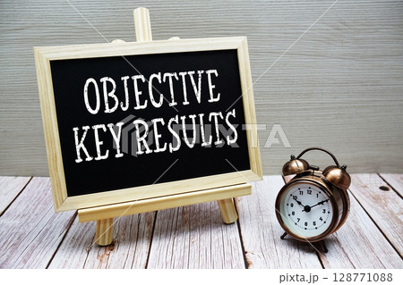 Objective Key Results text written on chalkboard with alarm clock on wooden background 128771088