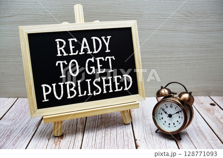 Ready To Get Published text written on chalkboard with alarm clock on wooden background Ready To Get Published text written on chalkboard with alarm clock on wooden background 128771093